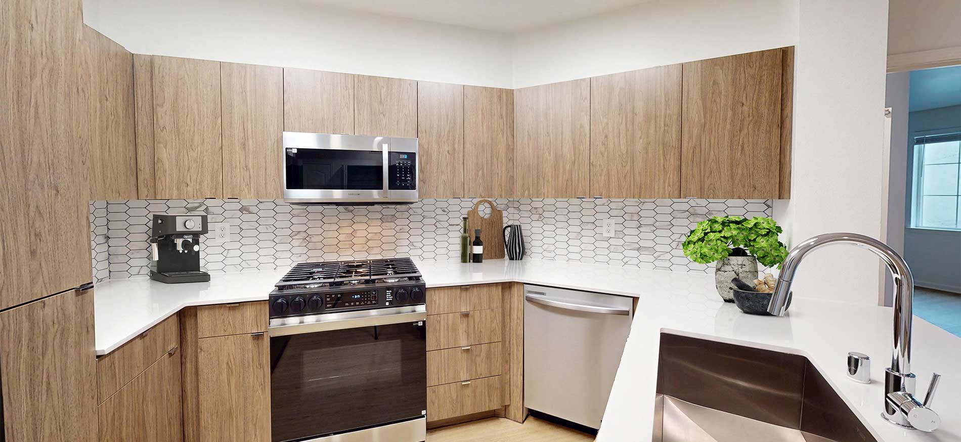 Modern kitchen with quartz countertops and stainless steel appliances at River Terrace in Santa Clara, CA.