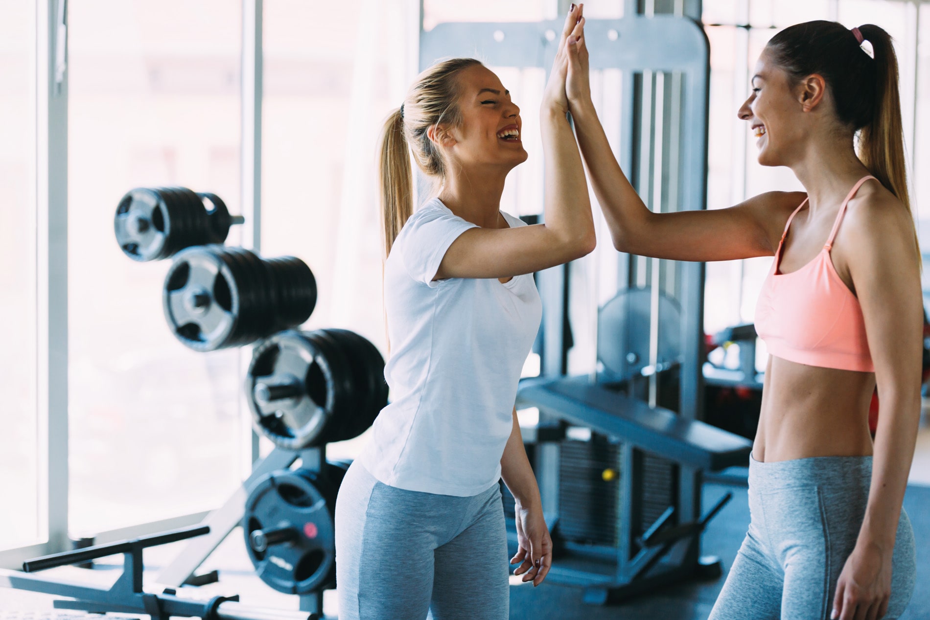 Friends high-fiving in the fitness center