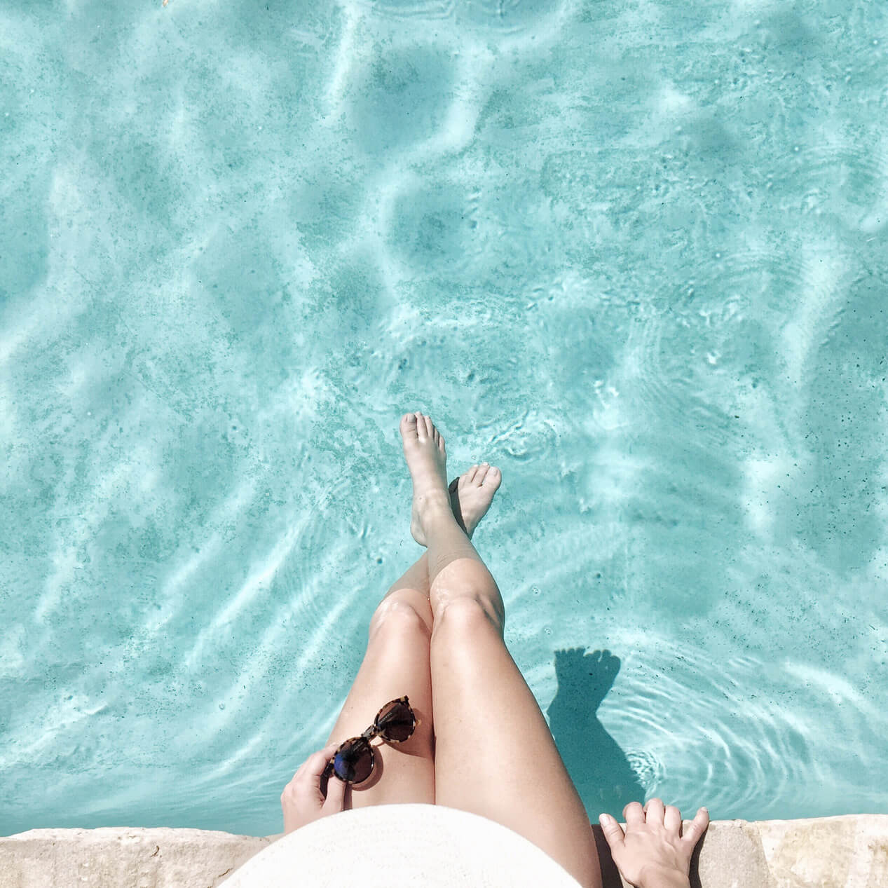 Woman sitting with her feet in the pool