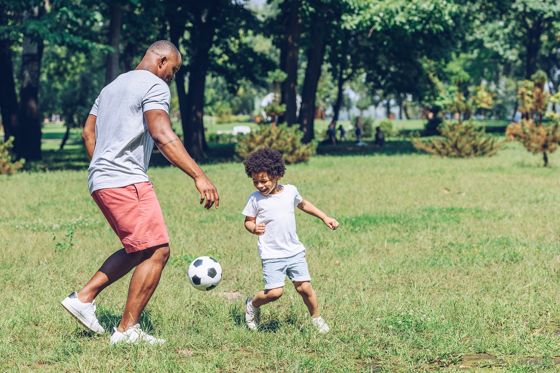 Father and son playing soccer ball