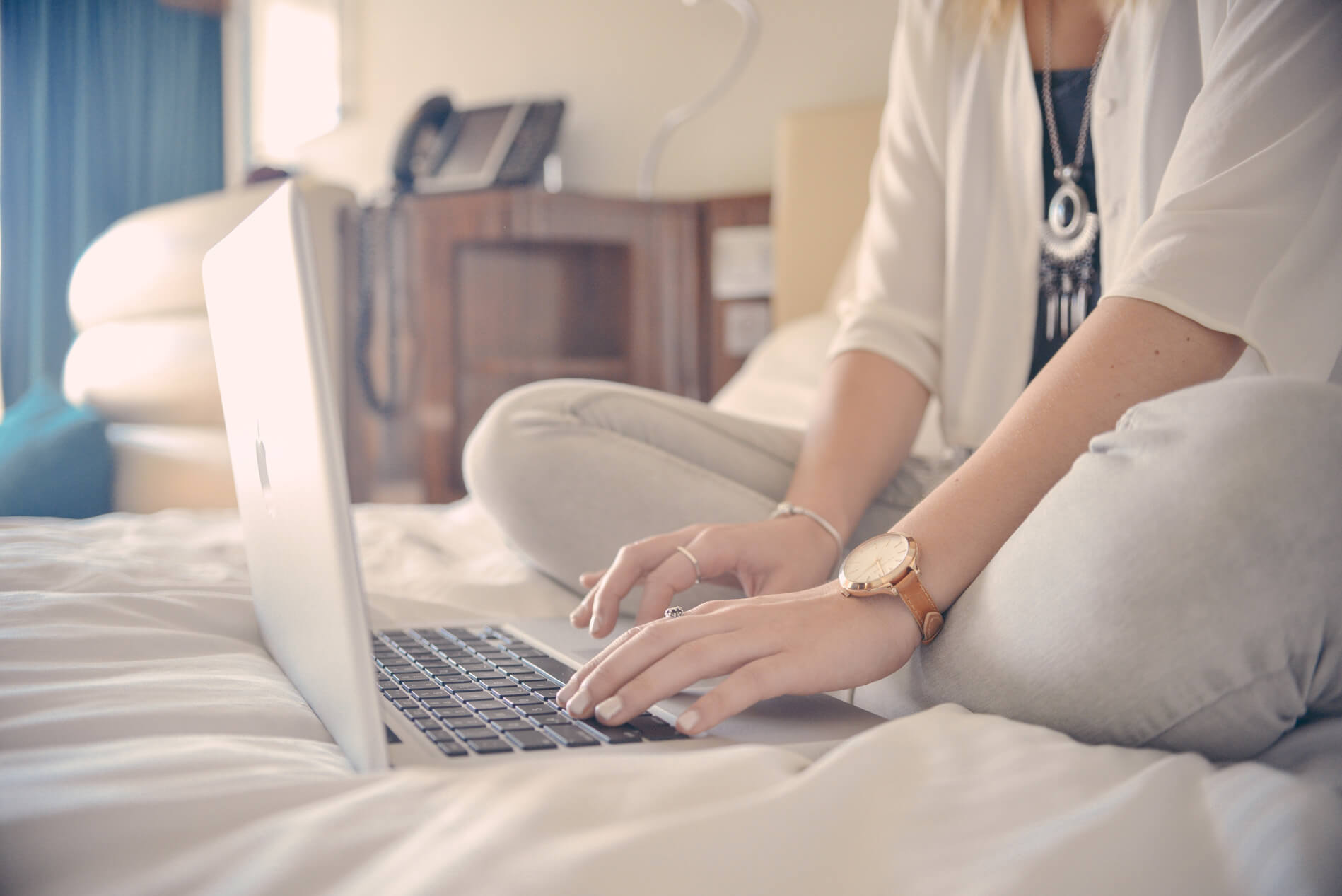 Person using laptop on bed