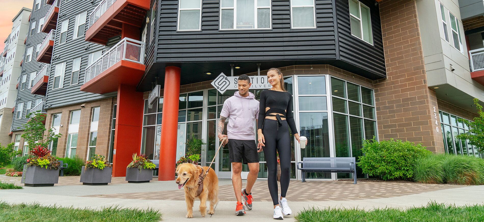 Couple walking outside of Station on Silver with dog