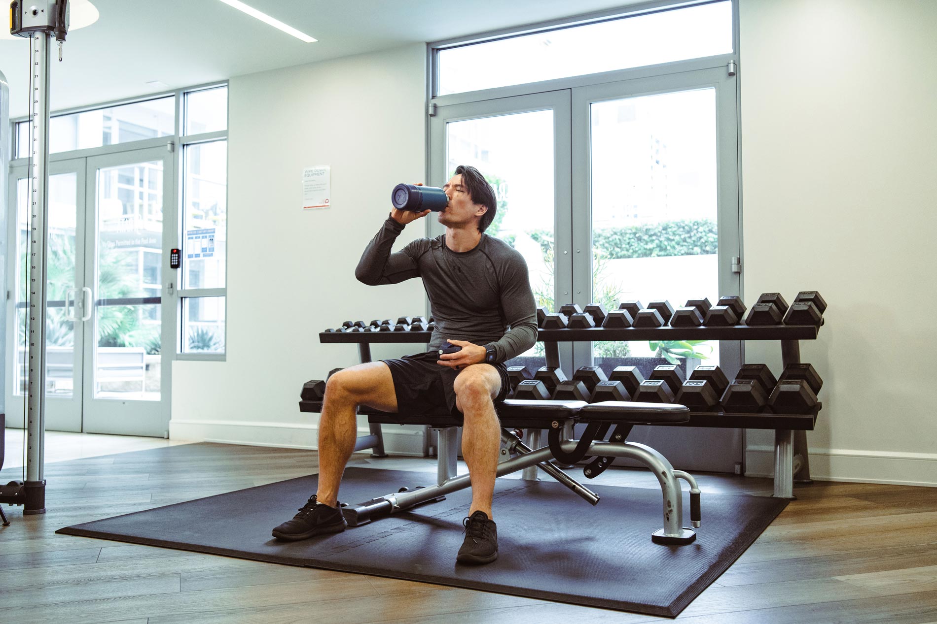 Strata man drinks water by free weights