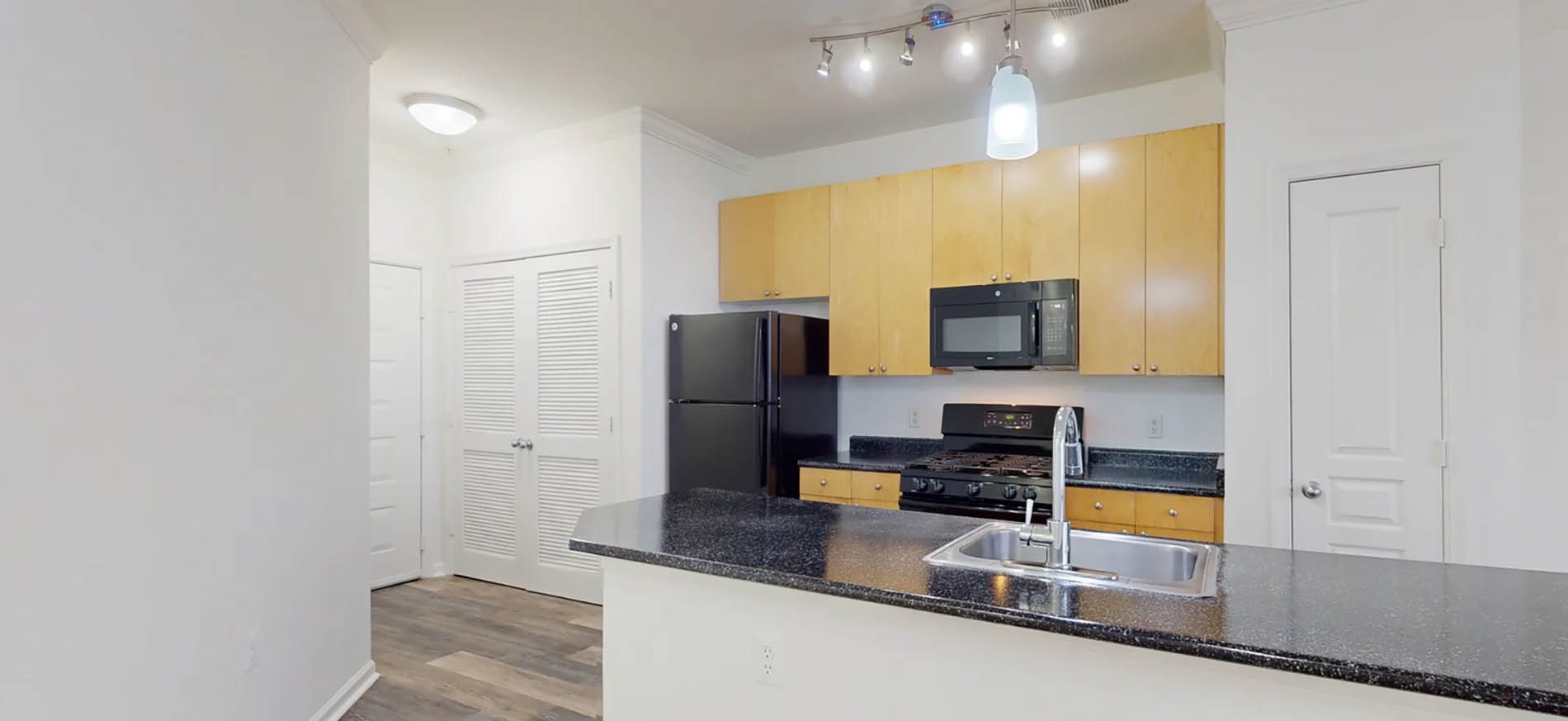 Sullivan Place kitchen with black counter top and stainless steel appliances