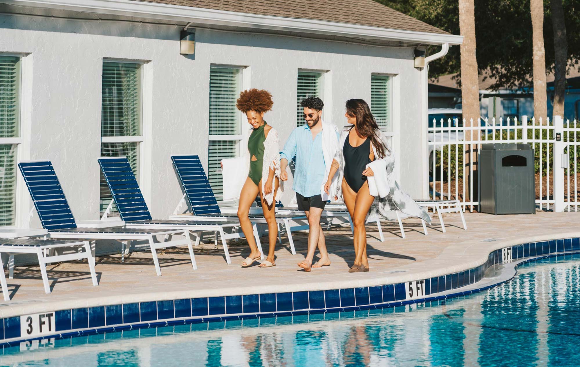 Summit West three people walk by the pool