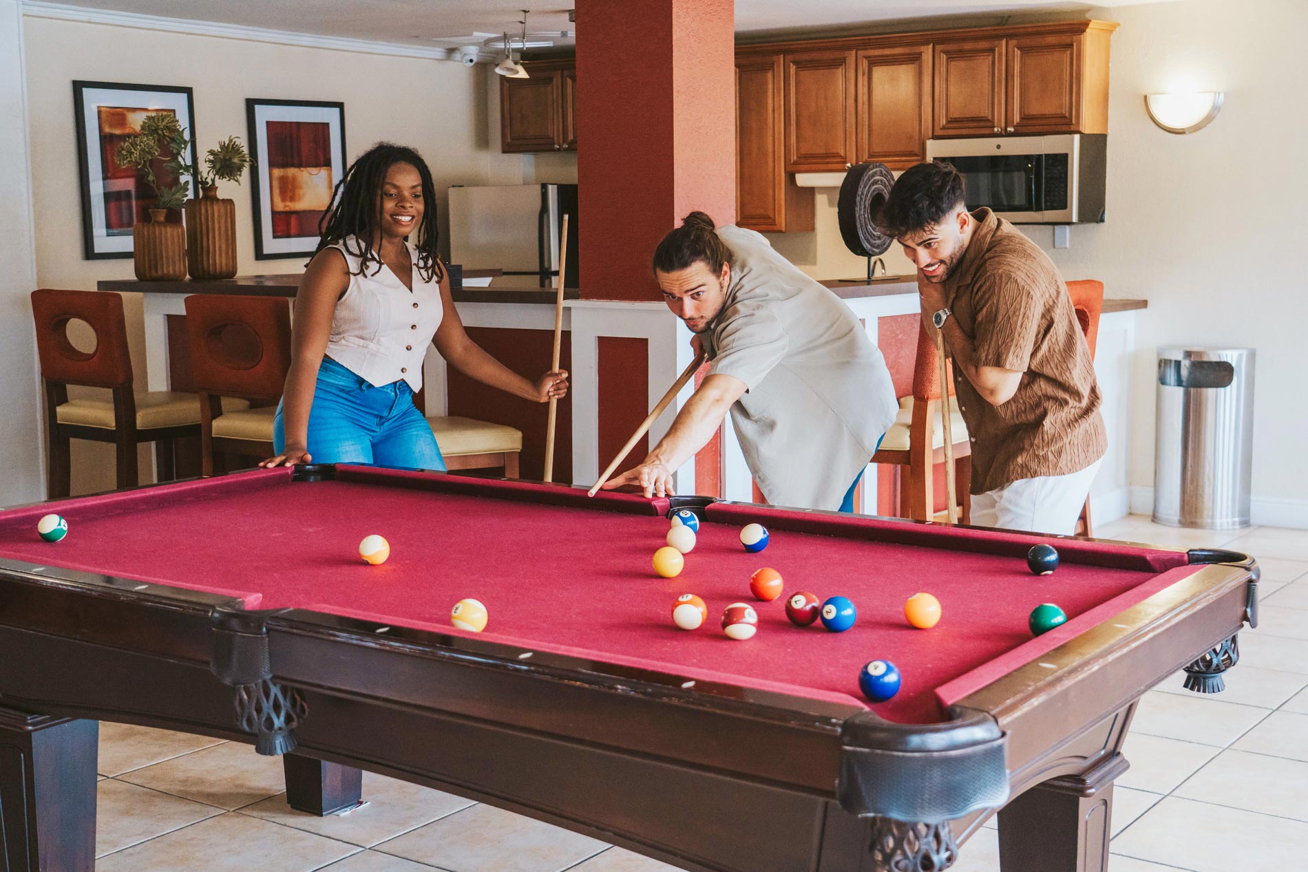 The Breyley three people play pool