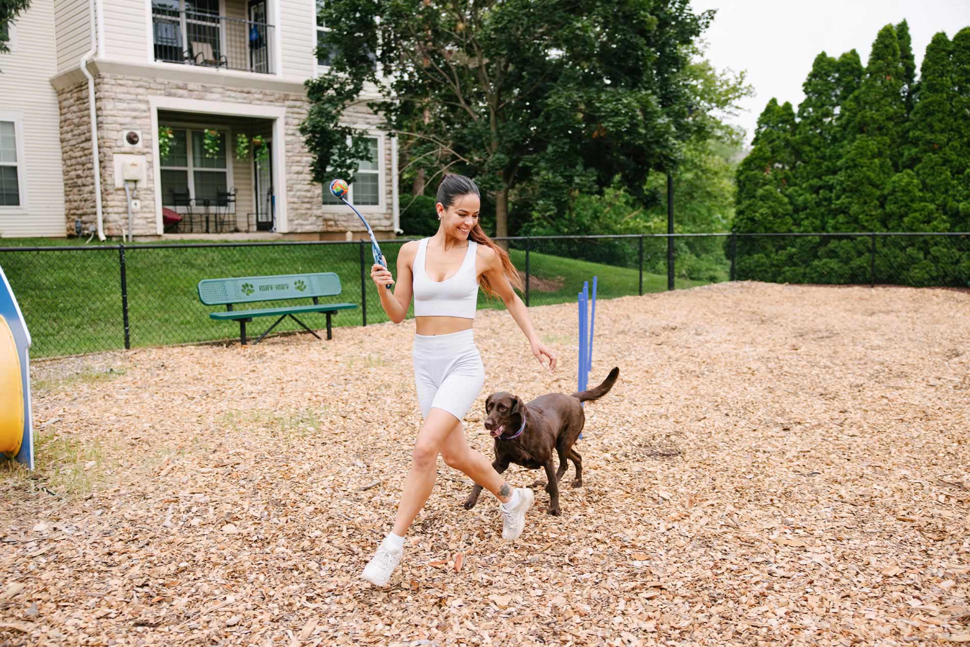 Courts At Dulles woman plays with dog in dog park