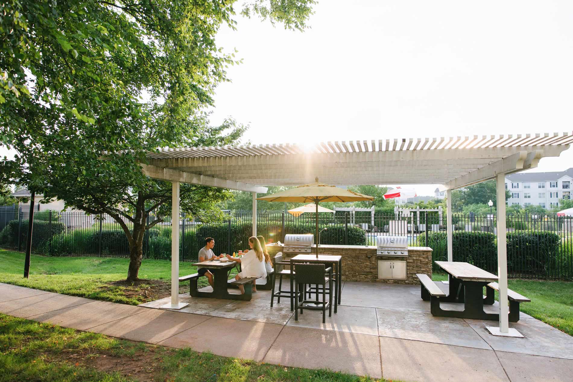 Courts at Dulles three people eat at grilling area