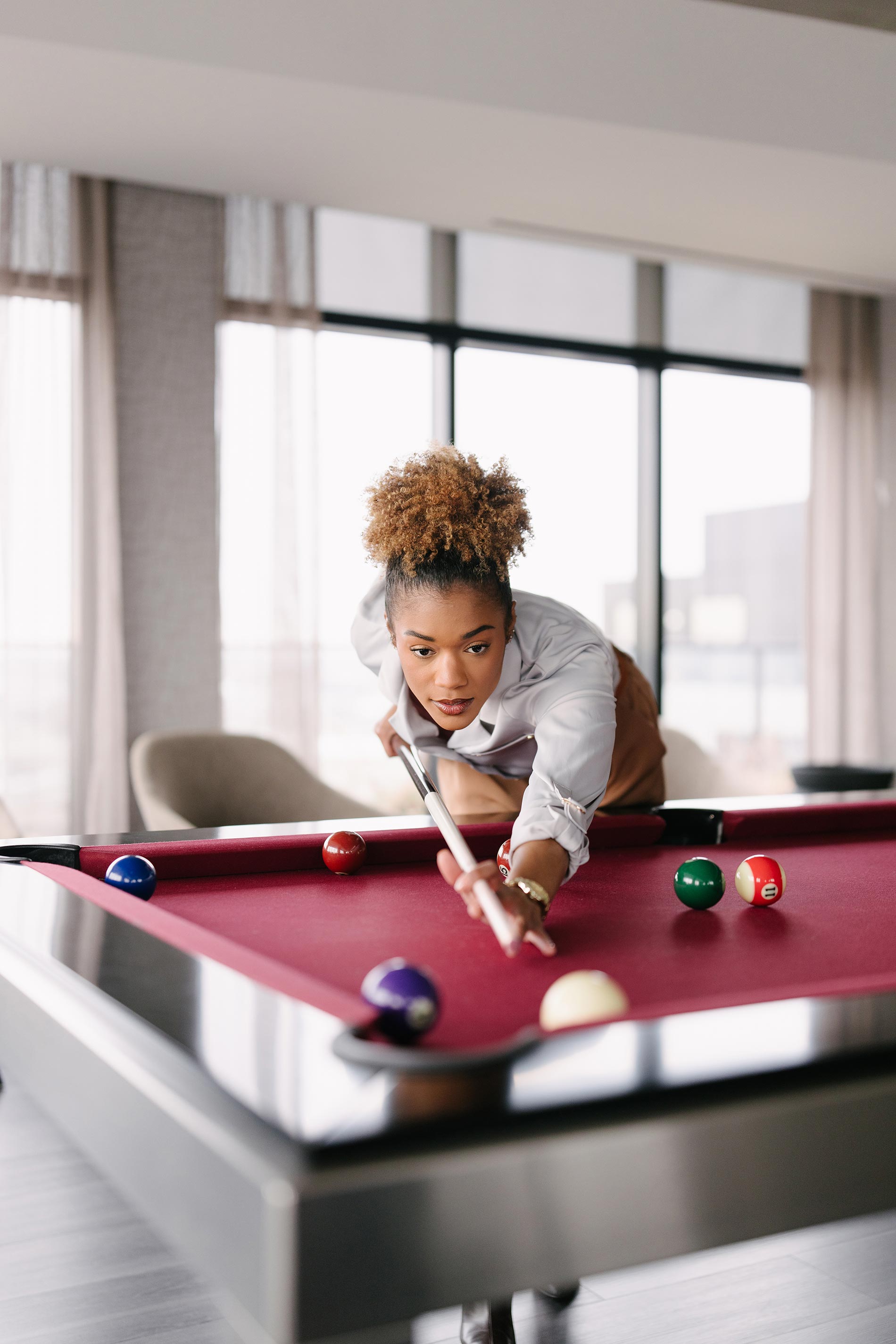 The MO woman plays a game of pool in the penthouse lounge