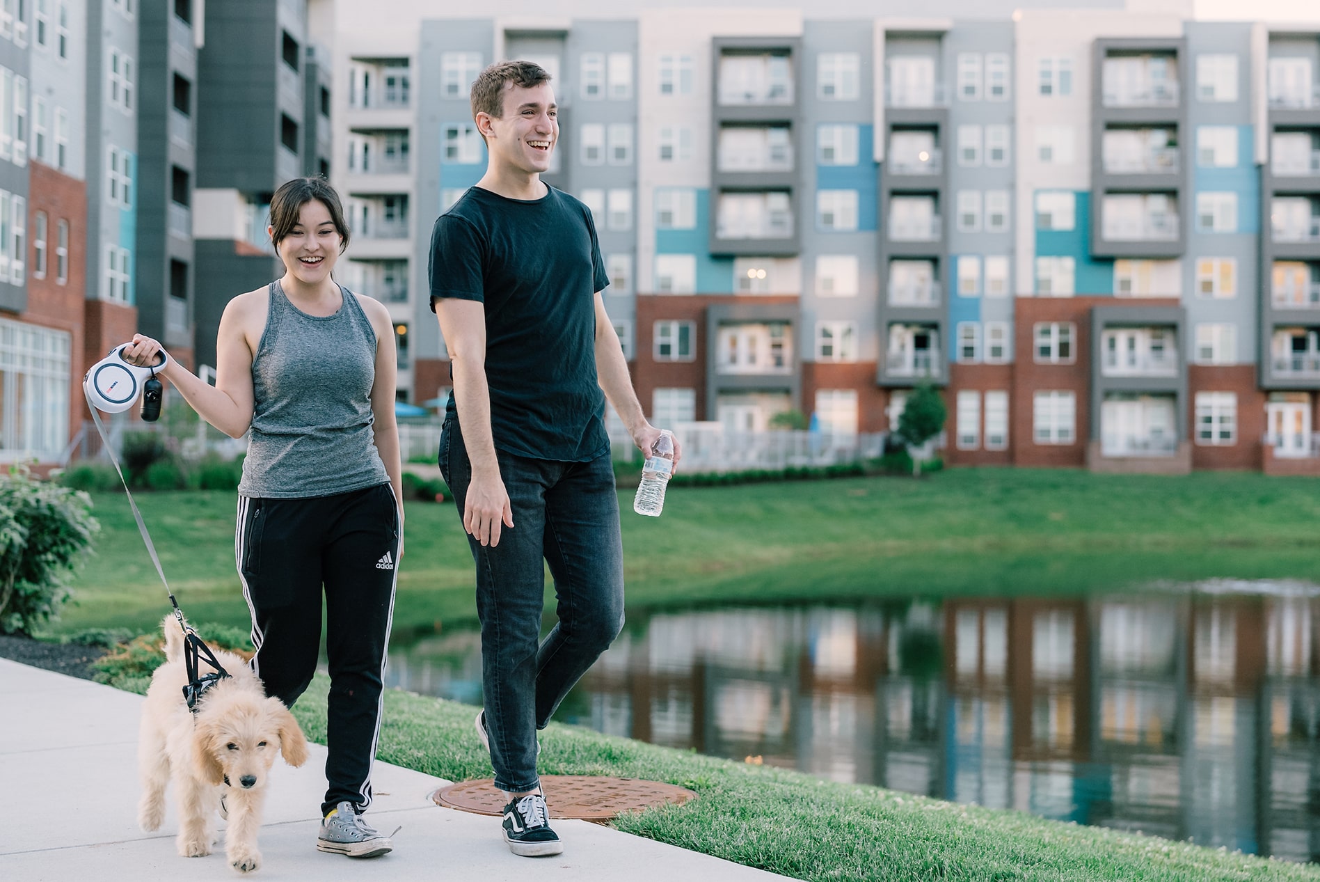 Smiling couple walking puppy at The Smith pond