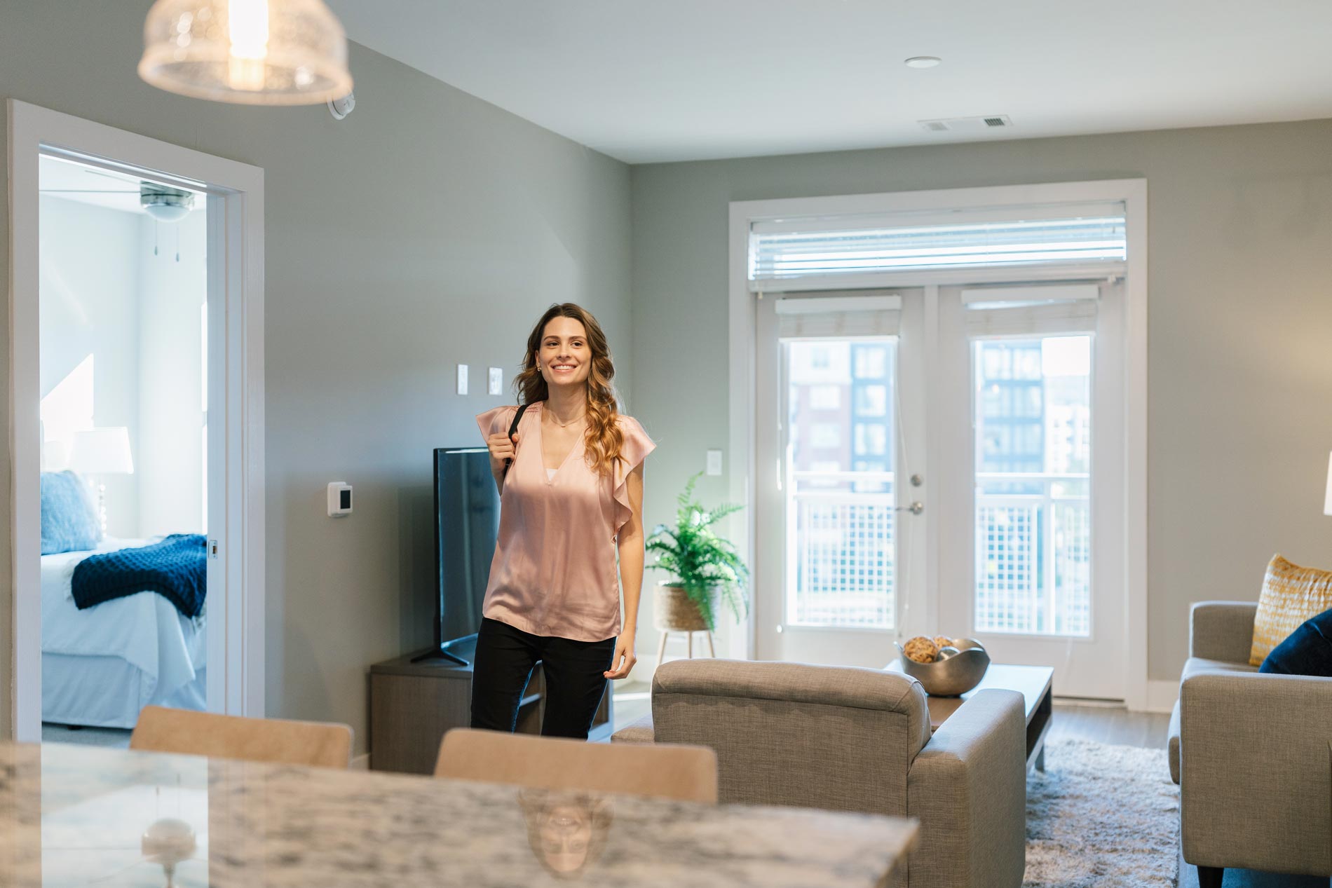 The Smith woman walks through furnished living room