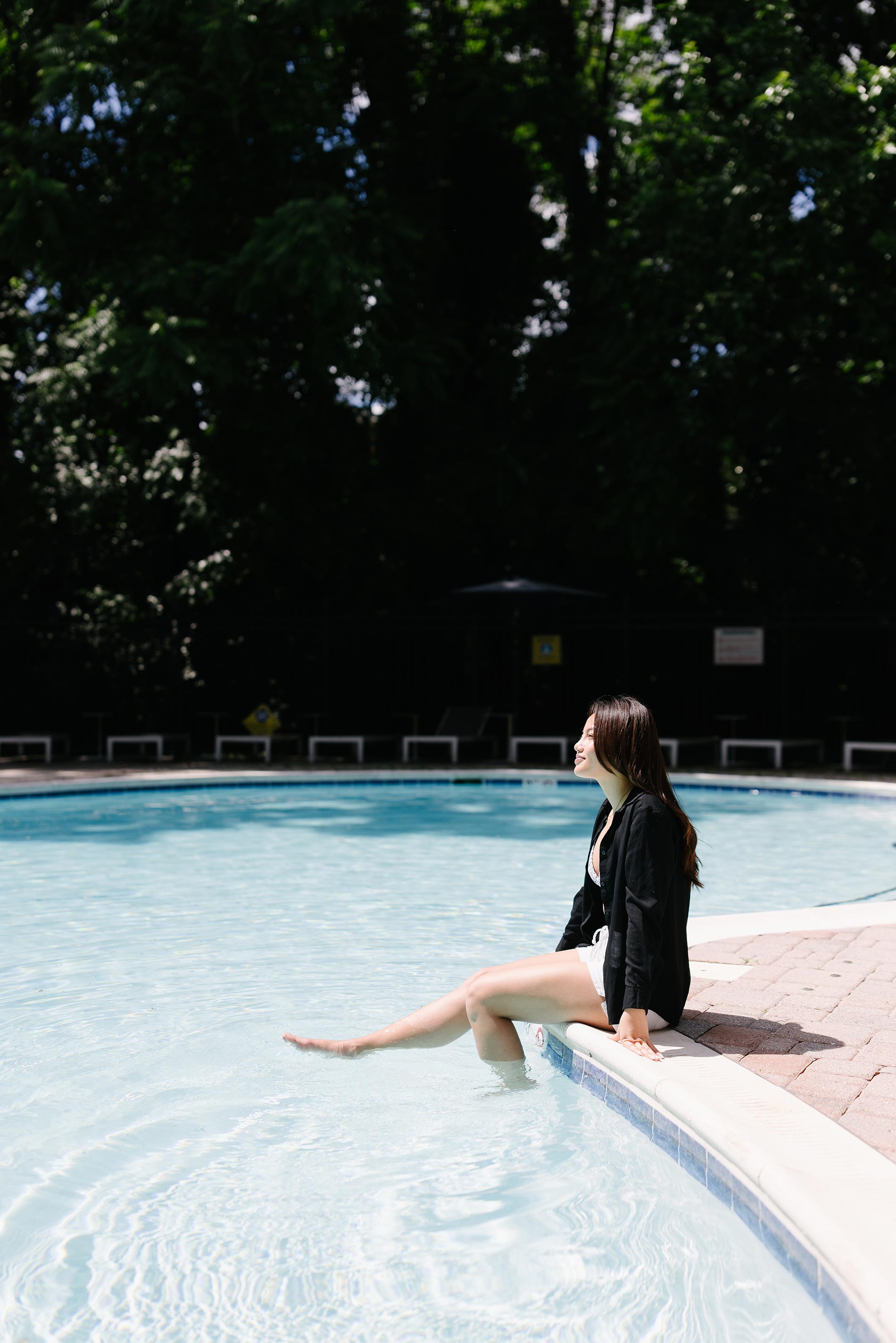 Whitmore apartments woman sits with feet in pool