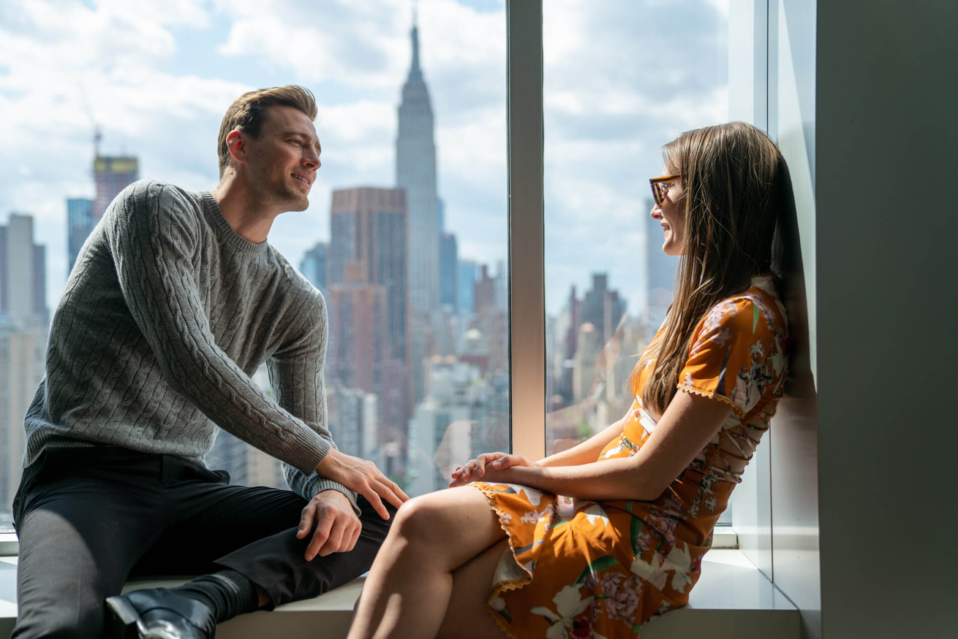 Couple sitting by window with city view