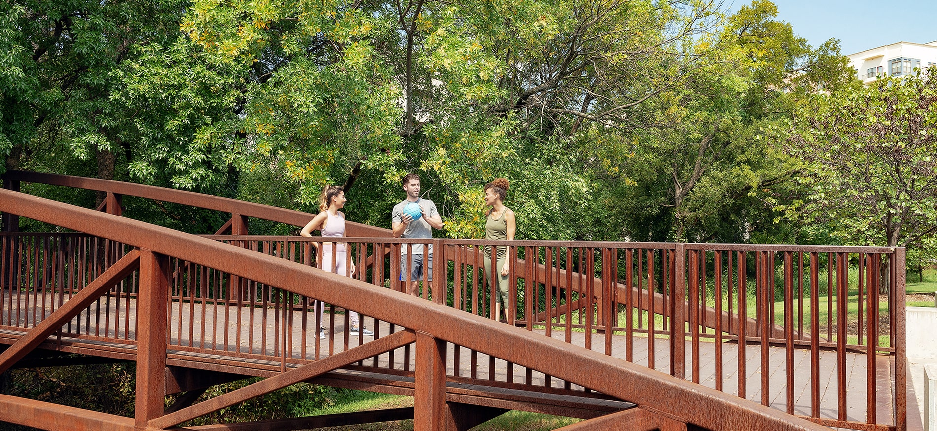 3 people standing on bridge in Vitruvian Park