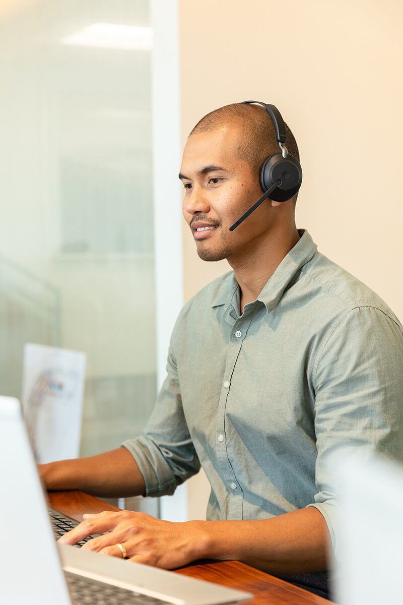 man working on computer with headset