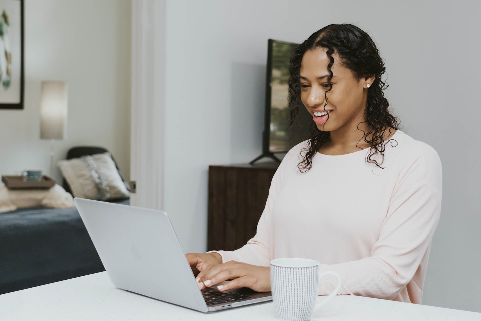 Woman sitting at kitchen counter using laptop computer Woman sitting at kitchen counter using laptop computer