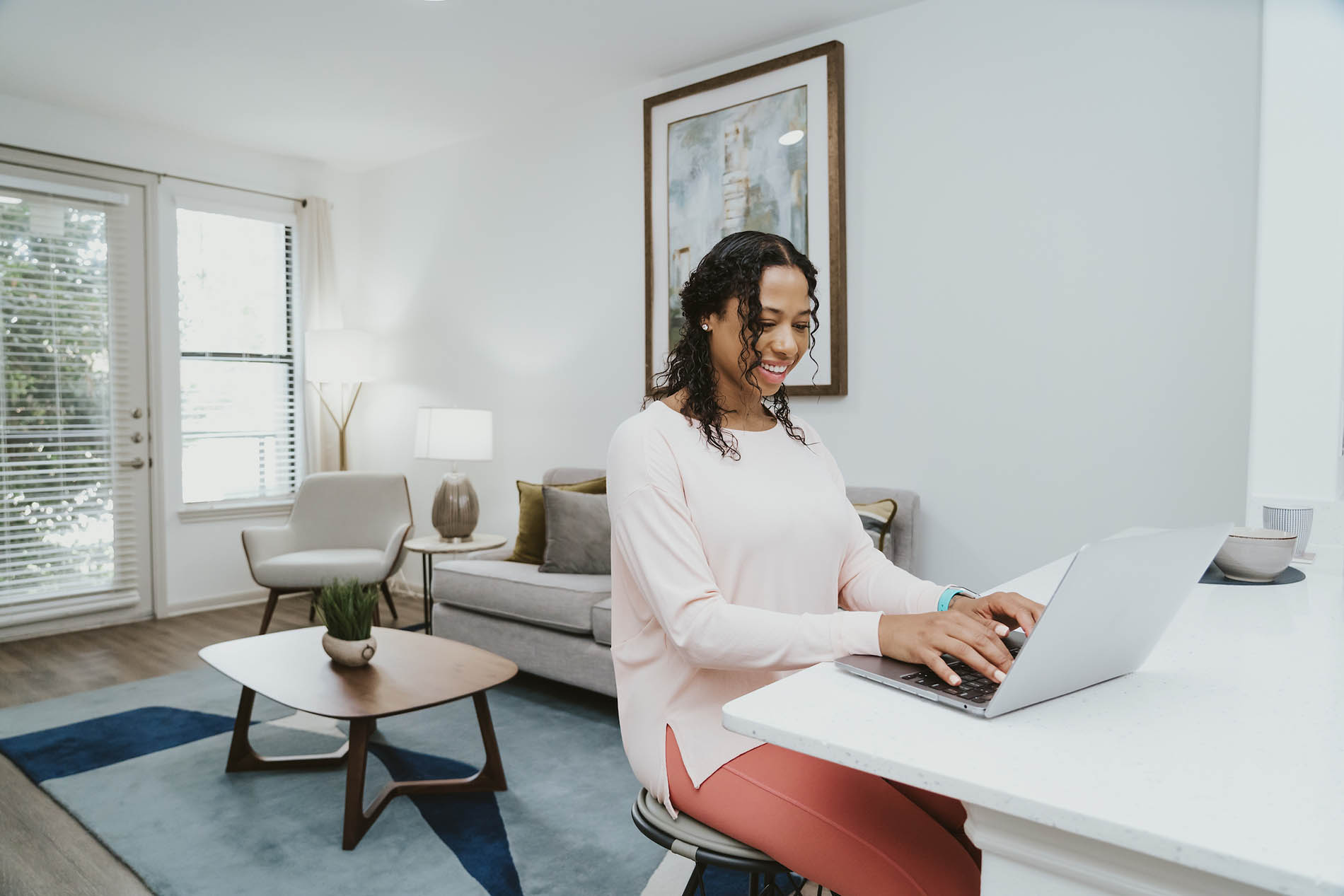 Woman sitting at kitchen counter using laptop computer