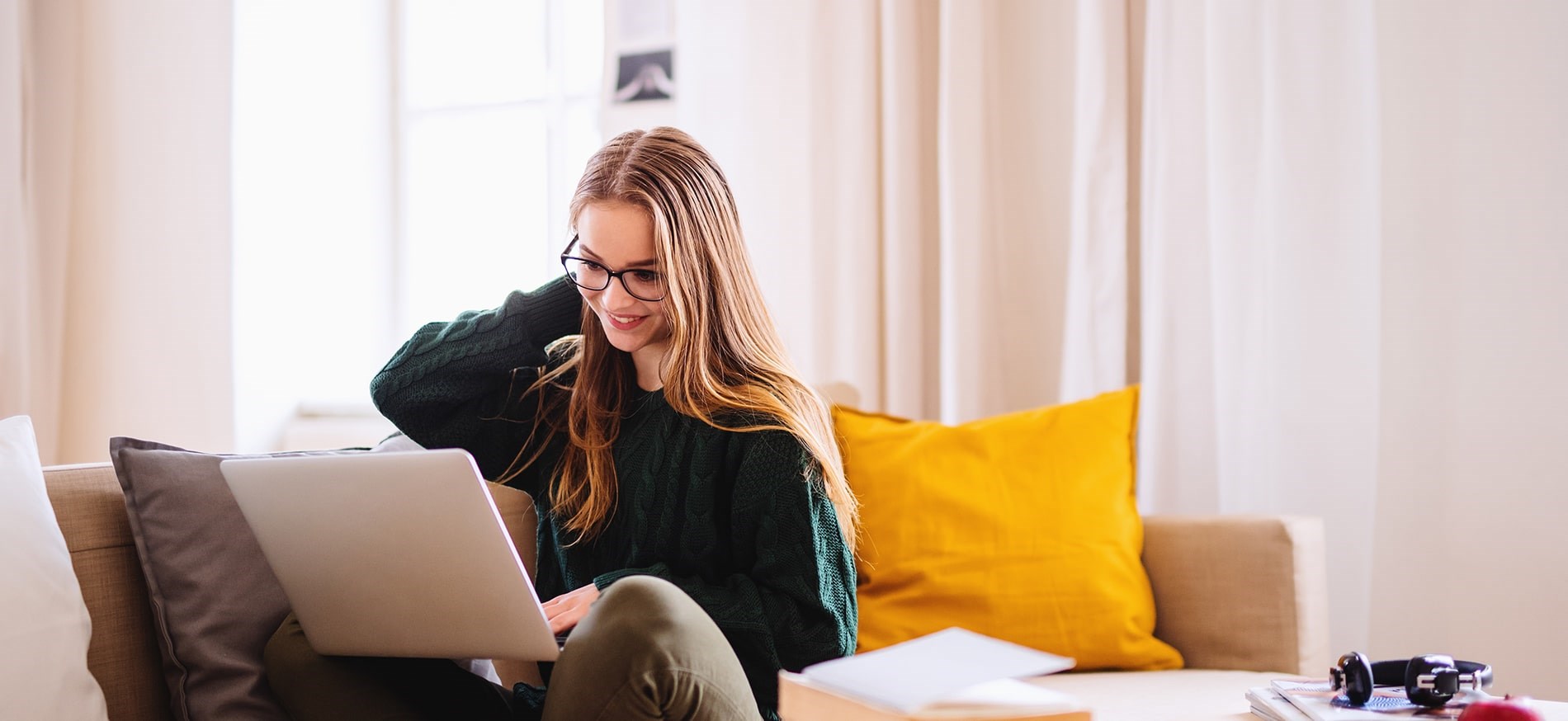 Happy woman working on laptop on couch Happy woman working on laptop on couch