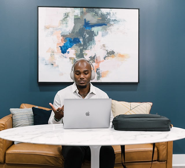 Man sitting at table with laptop open