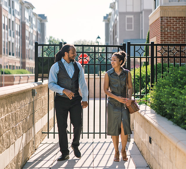 couple walking through gate touring community