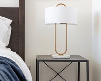 a bedroom with a bed and a lamp on a night stand
