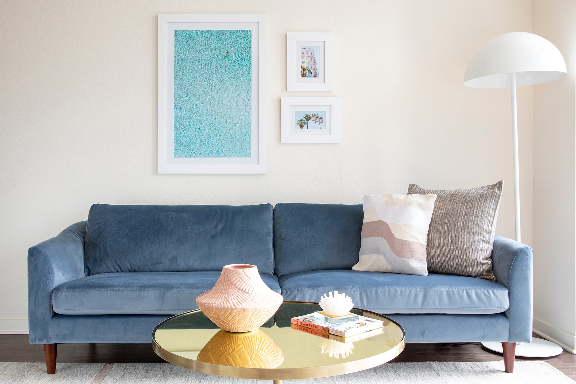 blue velvet couch with trendy artwork above