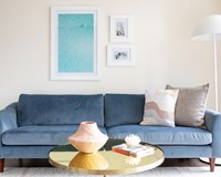 blue velvet couch with trendy artwork above