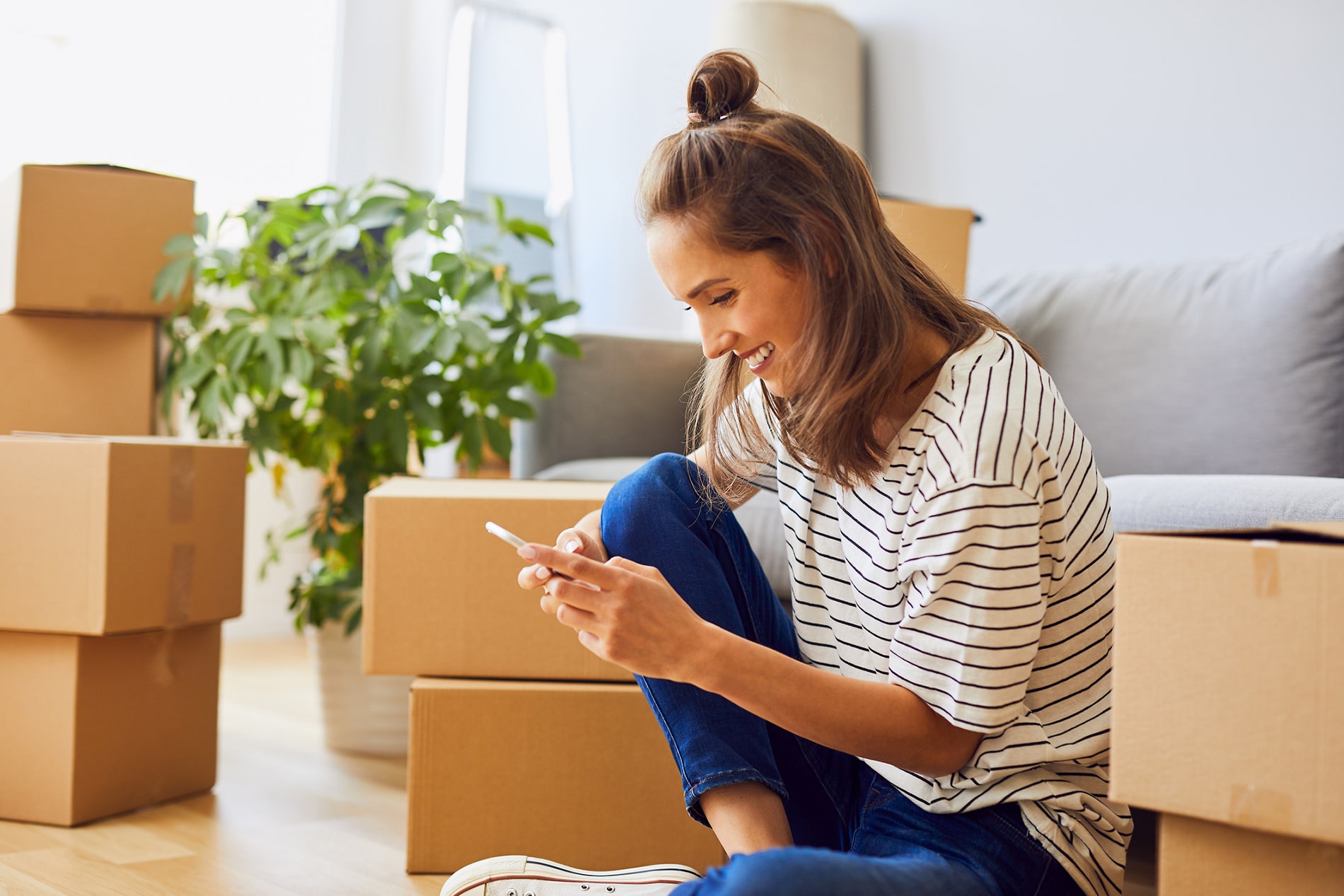 woman on phone surrounded by moving boxes