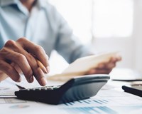 Man's hand using calculator