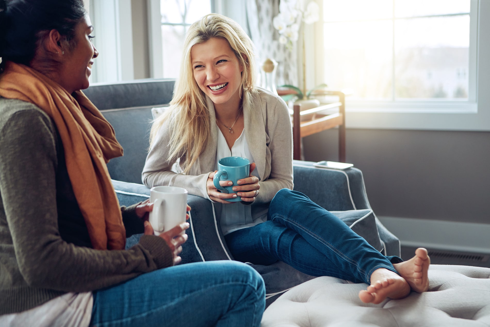 two women sitting on a couch talking to each other