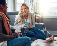 two women sitting on a couch talking to each other