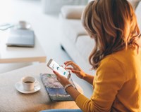 a woman sitting on a couch using a tablet